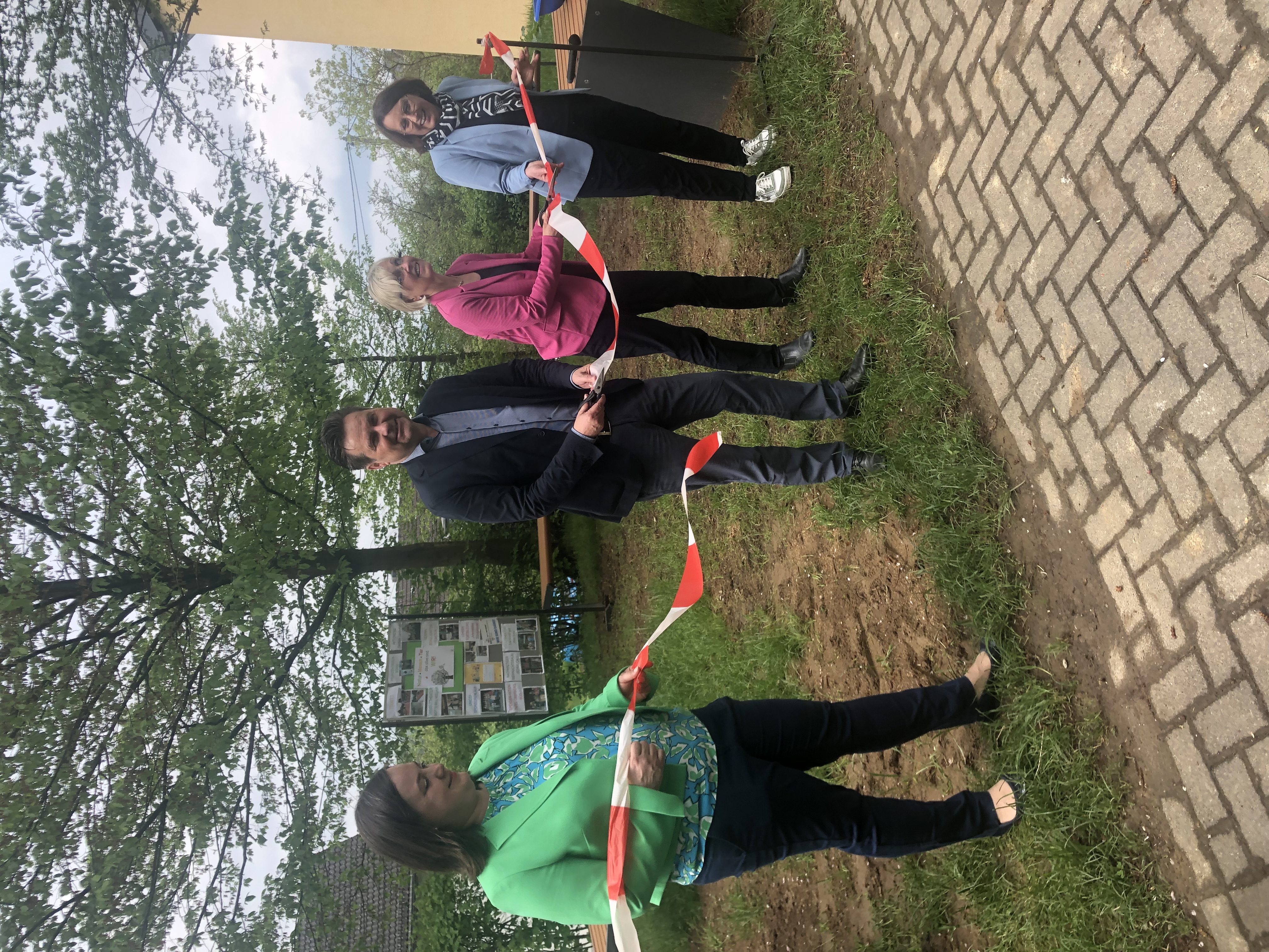 von links nach rechts: Schulleiterin Nadine Safarik-Rohr eröffnet mit Bürgermeister Ulrich Stücker, Anke Köster und Daniela Nyenhuis das grüne Klassenzimmer indem ein rot-weißes Band zerschnitten wird.